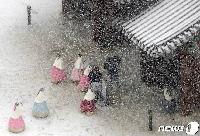 서울을 비롯한 중부 지방에 대설주의보가 내려진 15일 오후 서울 경복궁에서 관람객들이 눈길을 걷고 있다. 기상청은 이날 밤까지 서울을 비롯한 수도권, 강원, 충청 지역에 최고 10cm의 눈이 내릴 것으로 예보했다. 2022.12.15/뉴스1 ⓒ News1 김명섭 기자