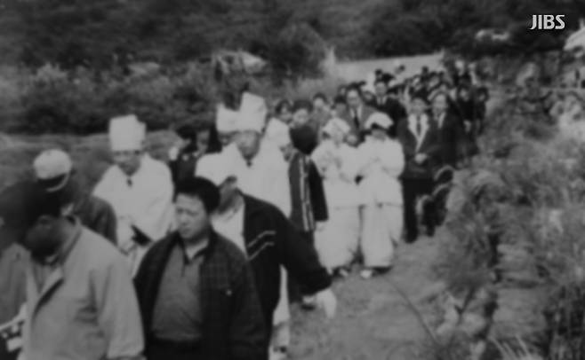 마을사람들이 함께 관을 들고 가는 모습