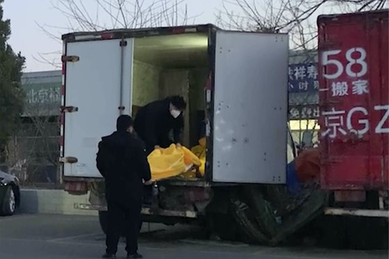 지난 16일 중국 베이징에 위치한 화장장에서 근무하는 직원들이 시신들을 옮기고 있다. AP=연합뉴스