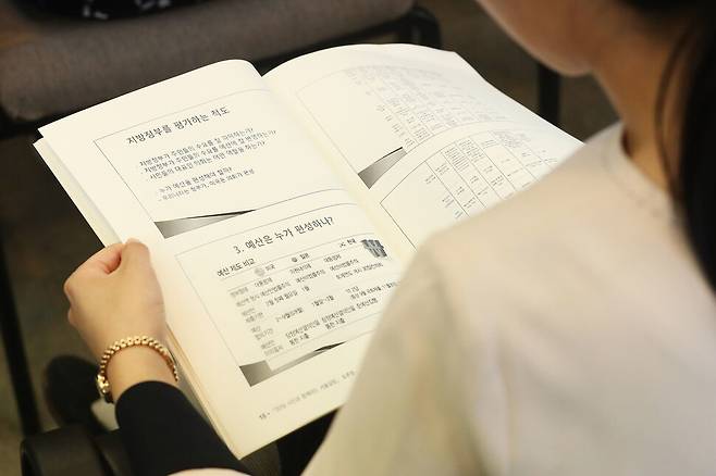 지난해 전국 지방자치단체에 잠겨 있는 돈(잉여금)이 69조원에 달해 ‘돈맥경화’ 수준에 이르고 있다. 사진은 한 시민이 예산 관련 토론회 자료집을 보는 모습. 연합뉴스