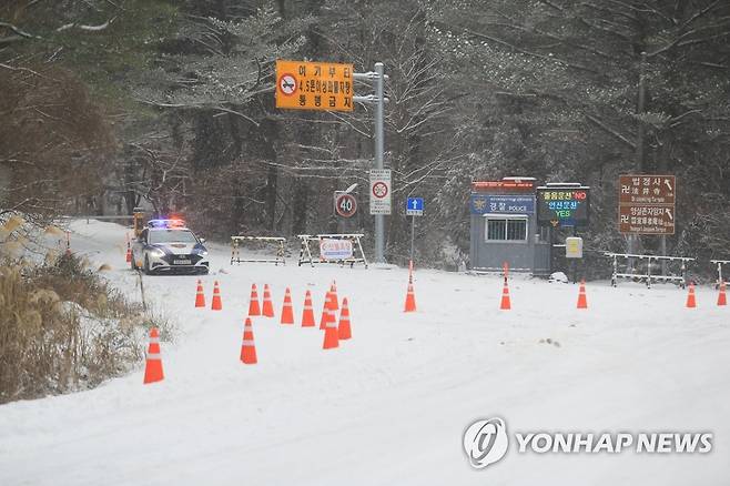 한라산 1100도로 전면 통제 (제주=연합뉴스) 박지호 기자 = 제주도에 대설특보가 내려진 18일 오전 제주시 어승생 1100도로 입구에서 경찰이 전 차량의 출입을 막고 있다. 2022.12.18 jihopark@yna.co.kr