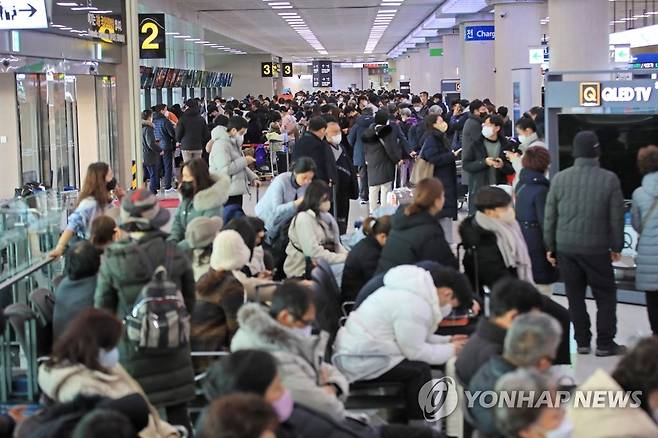 폭설에 제주공항 북새통 (제주=연합뉴스) 박지호 기자 = 제주도에 대설특보가 내려진 18일 오전 제주국제공항 출발층이 항공편을 기다리는 승객들로 크게 붐비고 있다. 2022.12.18 jihopark@yna.co.kr