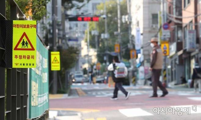 주정차 금지장소에 어린이 보호구역을 포함하고 이 구역에서 교통사고를 일으킨 운전자에게 의무적으로 특별 교통안전교육을 받도록 하는 내용이 담긴 개정 도로교통법 시행 첫날인 21일 서울 시내 한 초등학교에서 학생들이 등교하고 있다. /문호남 기자 munonam@