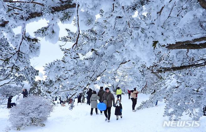 [제주=뉴시스] 우장호 기자 = 19일 오후 주말 동안 폭설이 쏟아진 제주 한라산 1100고지를 찾은 관광객들이 설경을 감상하며 즐거운 시간을 보내고 있다. 2022.12.19. woo1223@newsis.com