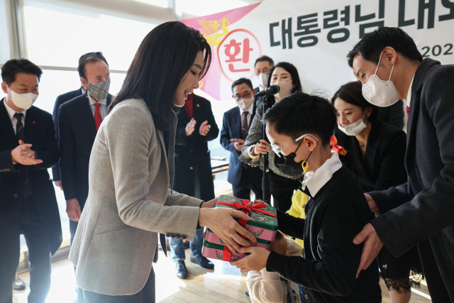 윤석열 대통령과 함께 17일 서울 서초동 아크로비스타 사저를 방문한 김건희 여사가 주민들에게 감사 인사를 전한 뒤 어린이들에게 선물을 전달하고 있다. 연합뉴스