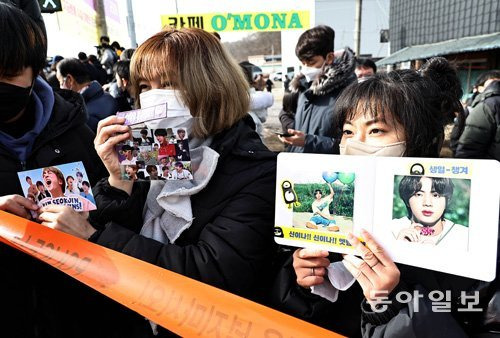 그룹 방탄소년단(BTS) 진(본명 김석진)이 13일 오후 경기 연천 제5사단 신병교육대로 입소했다. 일본, 홍콩 등 국내외에서 부대 앞을 찾은 팬들이 진의 사진을 들어보이고 있다. 양회성 기자 yohan@donga.com