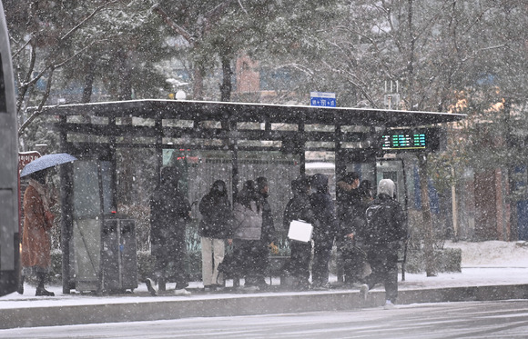 절기상 대설(大雪)을 하루 앞둔 지난 6일 경기도 수원시 영통구 망포동 한 버스정류장에서 시민들이 함박눈을 맞으며 버스를 기다리고 있다.(기사와 무관한 사진) [사진=뉴시스 ]