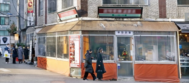 20일 서울 서교동 골목길의 한 음식점. 가게 바깥 테두리를 따라 불법 증축한 공간이 비닐로 가려져 있다. 이 음식점은 이 공간에 테이블을 여러 개 놓고 영업하고 있다.  김범준  기자