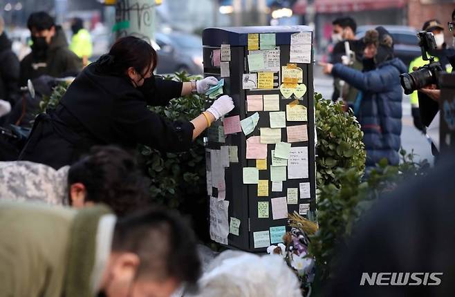 [서울=뉴시스] 김선웅 기자 = 이태원 참사 유가족협의회, 이태원 상인회, 자원봉사자 등이 21일 서울 용산구 이태원역 인근에 마련된 추모공간에서 참사 추모물품과 추모메시지 등을 정리하고 있다. 2022.12.21. mangusta@newsis.com