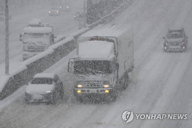 비상등 켜고 서행 (광주=연합뉴스) 차지욱 기자 = 대설 특보가 내려진 23일 오전 광주 서구 유촌동에서 차량이 비상등을 켜고 서행하고 있다. 2022.12.23 uk@yna.co.kr