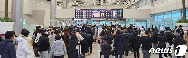 22일부터 제주를 덮친 강풍과 폭설 등으로 끊겼던 제주노선 항공기 운항이 24일 재개되면서 관광객 등이 제주를 떠나기 위해 제주국제공항 국내선 탑승장으로 들어서고 있다.2022.12.24/뉴스1 ⓒ News1 강승남 기자