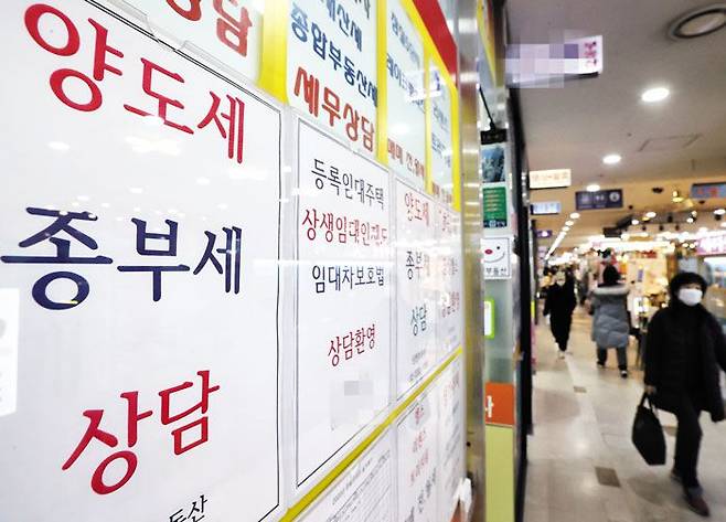 지난 21일 서울의 한 부동산 중개업소에 종부세 상담을 안내하는 문구들이 붙어 있다. 내년부터 종부세 부담이 줄어들고, 다주택자 취득세 인하 등이 예정돼 있어, 부동산 시장에 온기가 돌지 관심이 크다. /연합뉴스