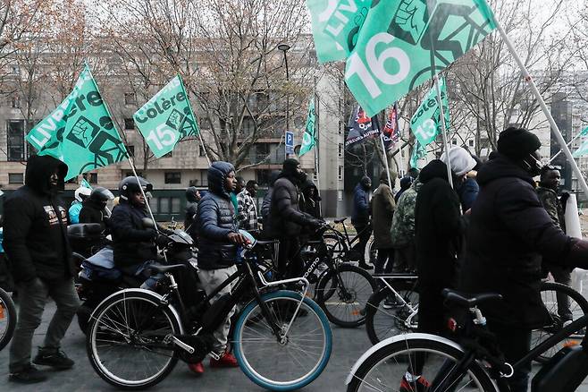 우버이츠 배달노동자들이 12월18일(현지시각) 프랑스 파리에서 세계 이주민의 날을 기념하는 연대 행진을 하고 있다. 프랑스 의회는 최근 노동력 부족을 메우기 위해 이주민의 거주와 취업을 허용하는 것을 골자로 한 이민법을 논의하고 있다.