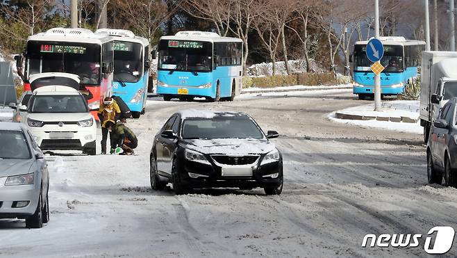 제주도 산지와 동·남·북부에 대설주의보가 발효된 18일 오전 제주시 아라동 제주대학교 앞 도로가 결빙돼 차량이 서행하고 있다. ⓒ News1 오현지 기자