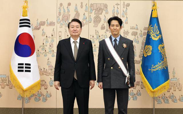 윤석열 대통령이 27일 서울 용산 대통령실 청사에서 '오징어게임'으로 미국 에미상 남우주연상을 받은 배우 이정재에게 금관문화훈장을 수여한 뒤 기념촬영을 하고 있다. 연합뉴스