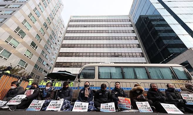 26일 전국민주노동조합총연맹 관계자들이 '노란봉투법'으로 불리는 노조법(노동조합 및 노동관계조정법) 2·3조 개정을 요구하며 점거 농성 중인 서울 여의도 민주당사 앞에서 민주노총 노조원들이 팻말을 들고 앉아 있다. 연합뉴스