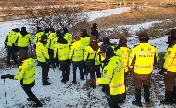 경찰들이 27일 택시기사를 살해하고 아파트 옷장에 시신을 숨긴 30대 남성이 전 여자친구도 살해한 뒤 시신을 유기했다고 자백하자 경기 파주 공릉천 주변을 수색하고 있다.뉴시스