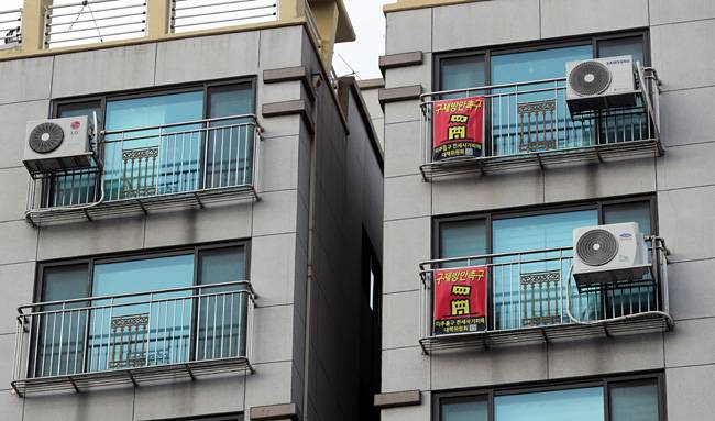 지난 23일 전세 사기 피해자들이 속출한 것으로 알려진 인천시 미추홀구 모 아파트 창문에 구제 방안을 촉구하는 현수막이 걸려 있다. 연합뉴스