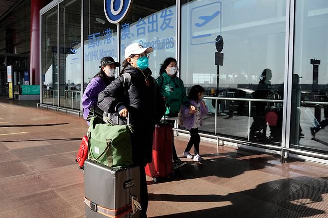 이달 13일 중국 베이징 서우두공항 터미널에서 마스크를 쓴 승객들이 걸어가고 있다./AP 연합뉴스