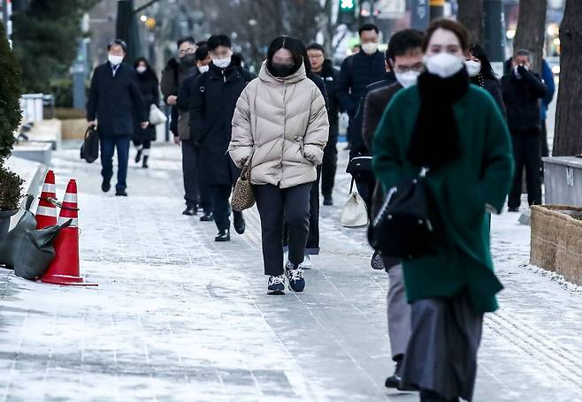 [서울=뉴시스] 정병혁 기자 = 추운 날씨가 이어지고 있는 28일 오전 서울 중구 시청역 인근에서 시민들이 눈 내린 길을 걷고 있다. 2022.12.28.