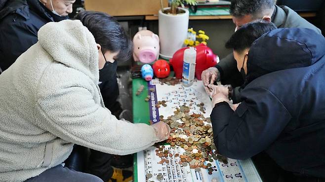 서울 중구청 환경공무관들이 연말을 맞아 돼지저금통을 개봉했다. 이들은 2014년부터 청소하면서 주운 동전을 모아 불우이웃에게 기부했다.  【사진 제공=서울 중구청】