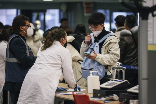 지난해 12월 29일 이탈리아 바레세의 밀라노 말펜사 공항에 도착한 중국발 입국자가 코로나19 관련 검사를 받고 있다. AP뉴시스