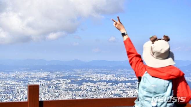 [광주=뉴시스] 이영주 기자 = 무등산국립공원 정상 개방 행사가 열린 8일 오전 광주 무등산국립공원 지왕봉 전망대에서 한 시민이 광주 시내를 배경으로 포즈를 취하고 있다.  2022.10.08. leeyj2578@newsis.com