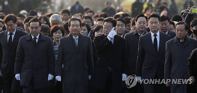 이재명 대표, 노무현 전 대통령 묘역 참배 (김해=연합뉴스) 김동민 기자 = 더불어민주당 이재명 대표가 1일 오후 경남 김해시 진영읍 봉하마을 노무현 전 대통령 묘역을 참배하고 있다. 
    너럭바위로 이동하는 모습. 2023.1.1 image@yna.co.kr