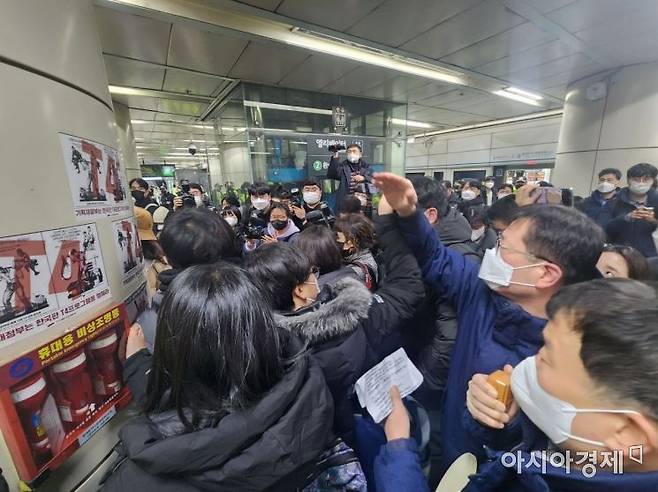 서울교통공사 직원들이 3일 오전 동대문역사문화공원 4호선 승강장에서 전국장애인차별철폐연대 활동가들의 불법 부착물 부착 행위를 저지하고 있다./사진=최태원 기자 skking@