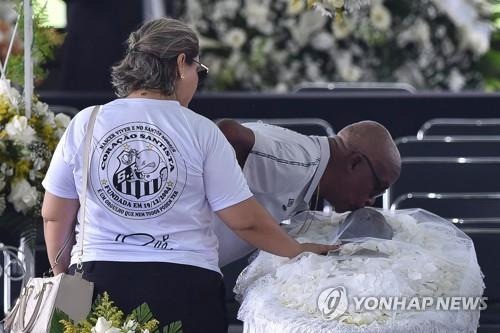 옛 동료와 축구황제의 작별 키스 (산투스[브라질 상파울루주] AFP=연합뉴스) 전 산투스 축구선수였던 세르지뉴 슐라파가 2일(현지시간) 산투스 빌라 베우미루 축구장에 안치된 펠레에 작별 키스를 하고 있다. 2023.1.3.