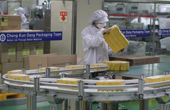 An employee boxes cold medicine at a pharmaceutical firm's plant on Thursday as demand for the medicine continues to grow. [YONHAP]