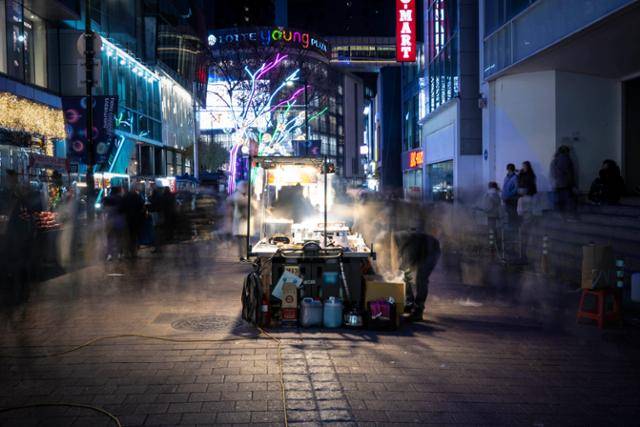 외국의 야시장 거리나 서울의 명동길처럼 노점이 특정 공간과 뗄 수 없는 관계가 된 경우가 많다. 그러나 온전히 합법도, 불법도 아닌 노점의 애매한 법적 지위가 사회적 갈등을 부추기고 있다. 3일 오후 서울 중구 명동길의 한 먹거리 노점이 지나는 인파 사이에서 환히 불을 밝히고 있다.