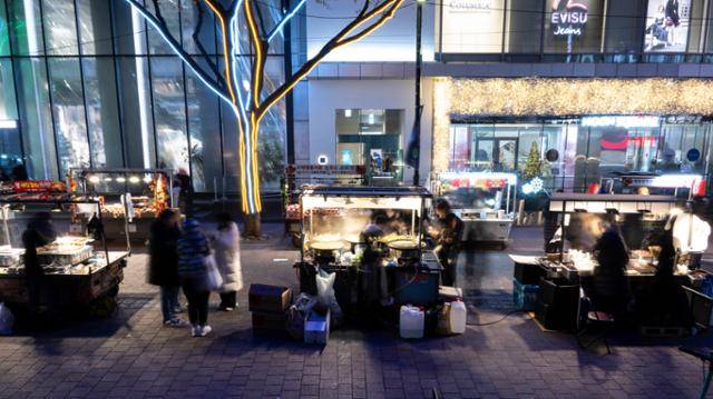 3일 오후 서울 중구 명동을 찾은 관광객들이 길거리에서 음식을 먹고 있다.