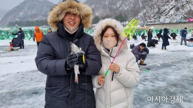 산천어를 낚은 관광객이 즐거워하고 있다. [라영철]