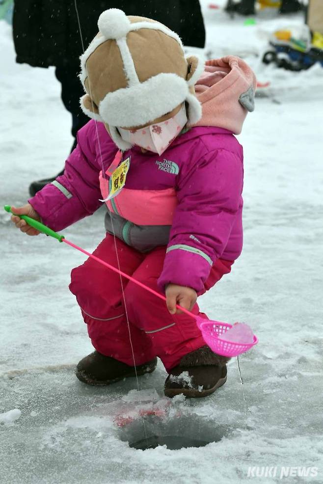'엄마 나 잘하고 있죠'  화천 산천어축제장을 찾은 한 어린이가 얼음구멍에 있는 얼음조각을 건져내고 있다.