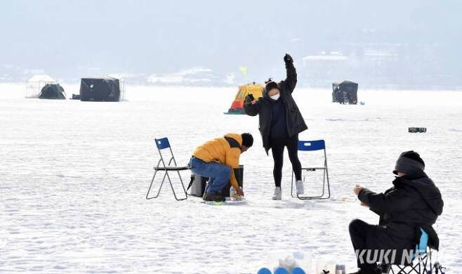 6일 오후, 춘천시 사북면 지촌리 빙어낚시터에서 여성 강태공이 낚은 빙어를 들어올리고 있다.