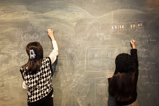 ‘헬가 스텐첼 사진전’에 마련된 칠판에 자유롭게 그림을 그려보는 소중 학생기자단.