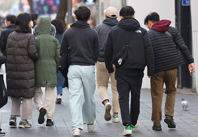 전국 대부분 지역이 평년기온 보다 3~5도 정도 높은 기온을 보인 10일 오후 서울 명동에서 한 시민이 외투를 벗어들고 길을 지나고 있다.  기상청은 11일은 평년보다 5도, 12일은 10도 높은 낮 기온 분포가 나타날 것으로 보인다고 이날 예보했다. 연합뉴스.