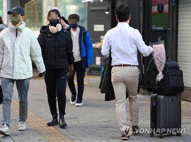 평년보다 높아진 기온, 얇아진 옷차림 (서울=연합뉴스) 김도훈 기자 = 전국 대부분 지역이 평년기온 보다 3~5도 정도 높은 기온을 보인 10일 오후 서울 명동에서 한 시민이 외투를 벗어들고 길을 지나고 있다.
    기상청은 11일 전국이 대체로 맑고, 낮 기온이 남부지방은 10도 내외, 중부지방은 5도 내외로 평년보다 높은 기온을 유지할 것으로 예보했다. 2023.1.10 superdoo82@yna.co.kr