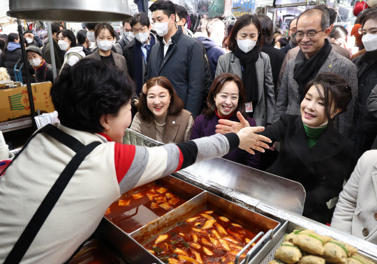 김건희 여사가 11일 대구 서문시장에서 만두 등 음식을 맛본 뒤 재방문을 약속하며 상인과 손을 잡고 있다. 사진=연합뉴스