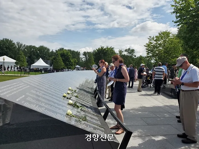 미국과 한국 시민들이 27일(현지시간) 미국 워싱턴에 새롭게 준공된 ‘한국전 전사자 추모의 벽’을 살펴보고 있다. 추모의 벽에는 한국전쟁에서 숨진 미군 전사자 3만6634명과 한국군 카투사 전사자 7174명의 이름이 새겨졌다. 2022.7.27. 워싱턴|김재중 특파원