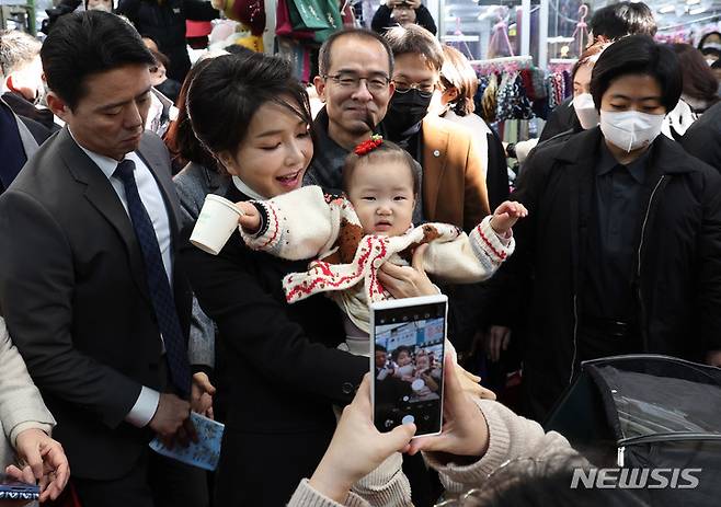 [대구=뉴시스] 홍효식 기자 = 윤석열 대통령 부인 김건희 여사가 11일 대구 서문시장을 찾아 아이를 안고 기념촬영을 하고 있다. (대통령실통신사진기자단) 2023.01.11. yesphoto@newsis.com