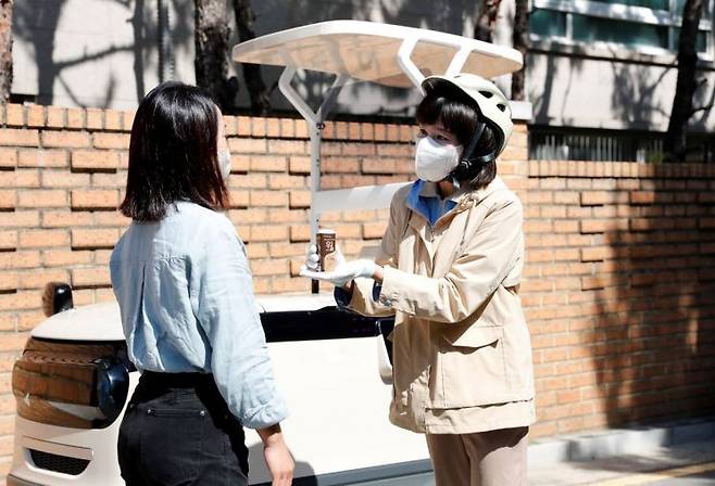 hy의 프레시 매니저가 고객에게 제품을 전달하고 있다.