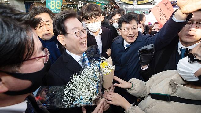 이재명 더불어민주당 대표가 11일 '국민 속으로, 경청투어' 민생 현장 방문으로 인천 남동구 모래내시장을 찾아 지지자로부터 꽃다발을 건네 받고 있다. 뉴스1