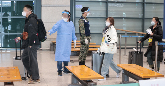 9일 오전 인천국제공항 제1여객터미널에서 중국발 입국자들이 입국장으로 들어서며 방역 관계자의 안내를 받고 있다. 연합뉴스