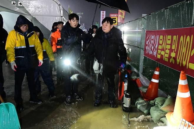 때아닌 겨울 폭우로 강원 화천군이 13일 산천어축제를 하루 휴장하기로 했다. 최문순 화천군수와 직원들이 이날 폭우가 내린 산천어축제장을 점검하고 있다. 화천군 제공.