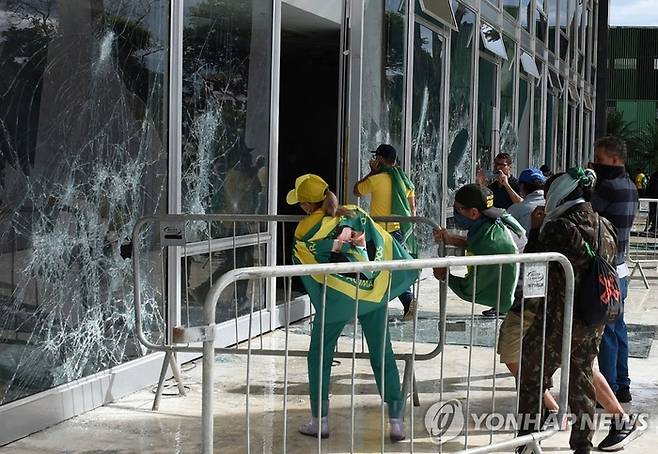 지난 8일(현지시간) 브라질 대법원 창문을 부수는 대선불복 시위대의 모습.[AFP = 연합뉴스]