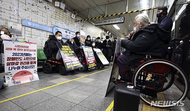 [서울=뉴시스] 최진석 기자= 박경석 전국장애인차별철폐연대(전장연) 공동상임대표를 비롯한 활동가들이 지난 5일 오전 서울 종로구 지하철 4호선 혜화역에서 장애인 이동권 문제를 알리는 선전전을 하고 있다. 2023.01.05. myjs@newsis.com