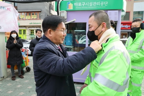 박강수(왼쪽) 서울 마포구청장이 환경공무관에게 ‘핫팩 목도리’를 전달하고 있다. 마포구 제공