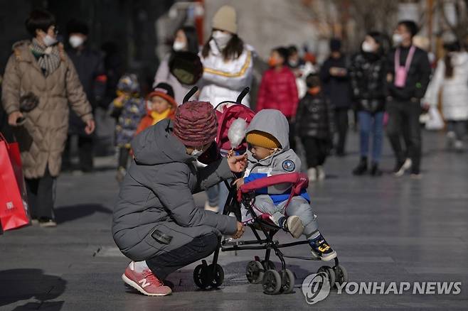 (AP=연합뉴스) 17일 중국 베이징의 쇼핑가를 거니는 사람들. 2023.1.17.